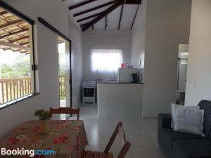 ein Wohnzimmer mit Tisch und Küche in der Unterkunft Pousada Villas do Arraial in Arraial d'Ajuda