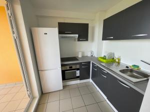 eine kleine Küche mit Kühlschrank und Spüle in der Unterkunft Le Petit Havre de Paix du Gosier in Le Gosier