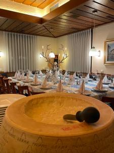 Cette grande chambre comprend une grande table avec des tables et des chaises. dans l'établissement Hotel Alessandro, à Neuried