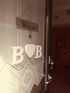 una puerta con la señal de bienvenida y un corazón en ella en Home n Breakfast Ca' di Toni, en Testana