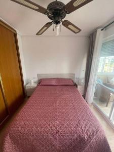 Schlafzimmer mit einem Bett und einem Deckenventilator in der Unterkunft Amplio y luminoso apartamento con piscina in Cala de Finestrat