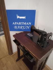 a sewing machine sitting on a table next to a sign at Barun apartman in Lusnić