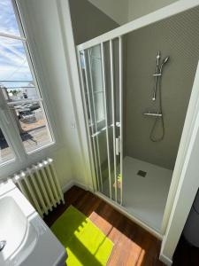 La salle de bains est pourvue d'une douche avec une porte en verre. dans l'établissement LA DOUCE Saumuroise, à Angers