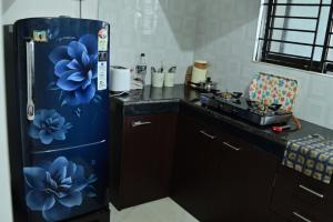 a kitchen with a refrigerator with blue flowers on it at Urban Green in Jorhāt