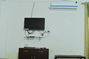 a flat screen tv hanging on a wall at Urban Green in Jorhāt