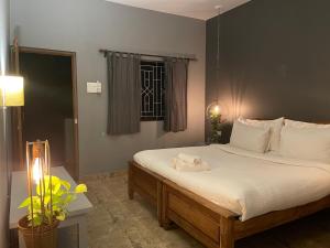 Tien B&B & Bistro في فاغاتور: غرفة نوم بسرير وملاءات بيضاء ونافذة