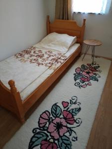 a bedroom with a bed with a flower rug at Barun apartman in Lusnić
