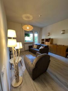 a living room with two couches and a table and a lamp at Casa Marina Giardino delle Rose in Marina di Carrara