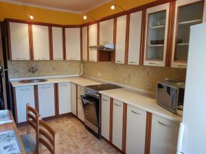 a kitchen with white cabinets and a stove top oven at Emides in Pobierowo