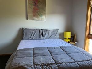 uma cama com um edredão azul num quarto em Howqua Inlet em Howqua
