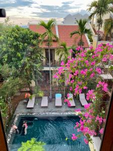 una vista aérea de una piscina con flores rosas en Villa Orchid Garden Riverside, en Hoi An