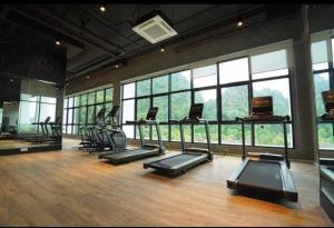 een fitnessruimte met een stel loopbanden en ramen bij Hotspring 1203 Studio Suite @ Sunway Onsen (4pax) in Tambun