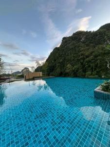 uma piscina com água azul e uma montanha em Hotspring 1203 Studio Suite @ Sunway Onsen (4pax) em Tambun