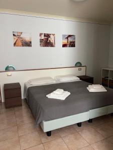 ein Schlafzimmer mit einem Bett mit zwei Handtüchern darauf in der Unterkunft Hotel Lydia in Grado