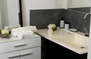 La salle de bains est pourvue d'un lavabo et de serviettes sur un comptoir. dans l'établissement La Domus Lemaitre 9 - Parking - TV - Wifi - Belgique, 