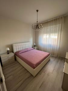 a bedroom with a large bed and a chandelier at Casa Marina Giardino delle Rose in Marina di Carrara