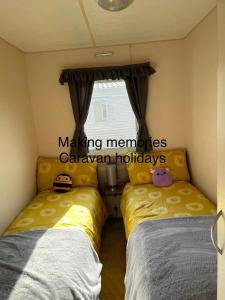 a bedroom with two beds and a window at Making Memories Holiday Caravan in Skegness