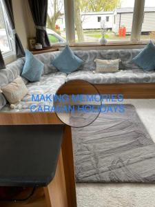 a couch in a living room with a window at Making Memories Holiday Caravan in Skegness