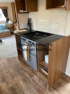 a kitchen with a stove and a counter top at Making Memories Holiday Caravan in Skegness