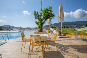 un patio con mesa y sillas junto a una piscina en Hotel Herbeira, en Cedeira