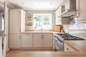 a kitchen with white cabinets and a stove at 4 Bedroom Townhouse 10mins walk from Shrewsbury Town Centre with Parking in Shrewsbury