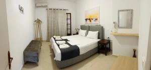 una camera con un grande letto e uno specchio di Yanna's Apartments a Sidari