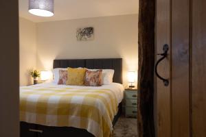 a bedroom with a bed with a yellow and white blanket at Family Country Cottage with Stunning Mountain Views in Myddfai