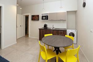 a kitchen and dining room with a table and yellow chairs at Casa Bomma in Messina