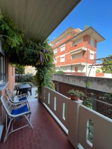 einen Balkon mit einem Stuhl, einem Tisch und einem Gebäude in der Unterkunft Casa Marina Giardino delle Rose in Marina di Carrara