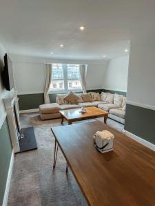 a living room with a couch and a table at The Great Pulteney Penthouse, Bath City Centre in Bath