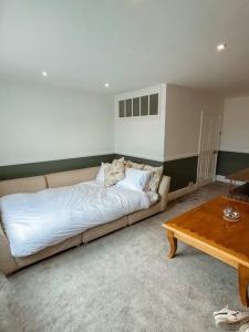 a large bed in a room with a table at The Great Pulteney Penthouse, Bath City Centre in Bath