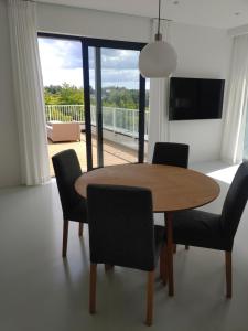 una sala da pranzo con tavolo e sedie e un balcone di Apartamenty HELIOS a Jastrzębia Góra