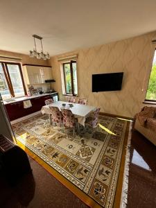een woonkamer met een tafel en stoelen op een tapijt bij Xanagah Villa in İsmayıllı