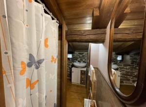 uma casa de banho com uma cortina de chuveiro com borboletas em Las Casitas de Requeixo em Requeixo