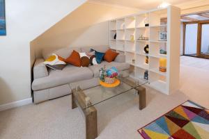 a living room with a couch and a glass table at Charming family house in High Wycombe in Buckinghamshire