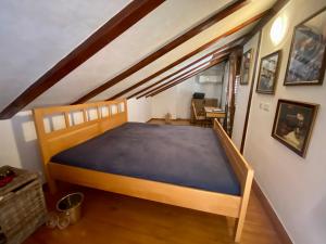 1 dormitorio con cama de madera y colchón azul en Romantic maisonette, en Piran