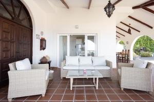 ein Wohnzimmer mit einem Sofa, Stühlen und einem Tisch in der Unterkunft Finca Villa Huerta in Icod de los Vinos