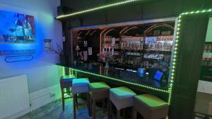 un bar verde con sgabelli in una stanza di Cecil Court Hotel a Bournemouth