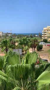 een uitzicht op een strand met palmbomen en een gebouw bij Paradise Rentals Denia VilaMar 2 in Denia