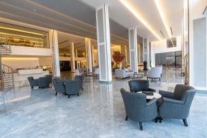 um átrio com cadeiras e mesas num edifício em فندق هوليداي الخليج النجاح em Riade