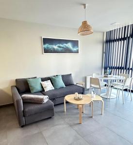 ein Wohnzimmer mit Sofa und Tisch in der Unterkunft APARTAMENTOS FREIXO-Rias Baixas in Cangas
