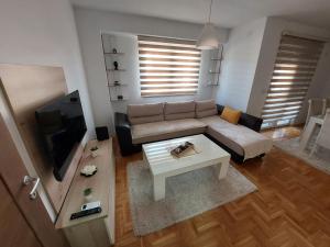 een woonkamer met een bank en een salontafel bij Apartment Gelić Family in Kumanovo
