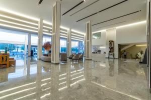een lobby met een grote lobby met stoelen en tafels bij فندق هوليداي الخليج النجاح in Riyad