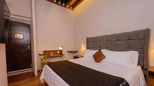 um quarto com uma cama grande e uma grande cabeceira. em Casa Eva Hotel Boutique & Spa em Cholula