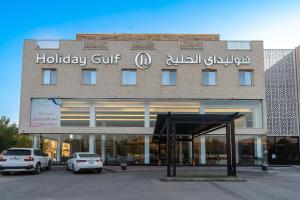 um edifício com carros estacionados em frente em فندق هوليداي الخليج النجاح em Riade