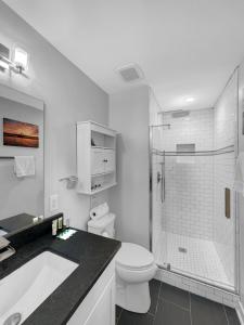 a white bathroom with a toilet and a shower at Cozy Island Cottage in Charleston