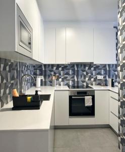 eine Küche mit weißen Schränken und einer Spüle in der Unterkunft APARTAMENTOS FREIXO-Rias Baixas in Cangas