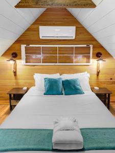 a bedroom with a large white bed with blue pillows at Cozy Island Cottage in Charleston