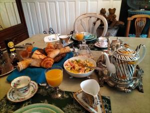 uma mesa com pequeno-almoço de pão e sumo de laranja em Le Jardin Secret & Spa em Saint-Brieuc