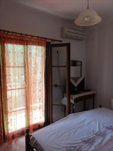 a bedroom with a bed and a large window at Mountain Voyage Residences in Vatoússa